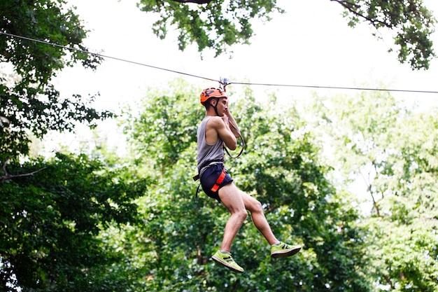 Man goes down on the rope in an entertainment park