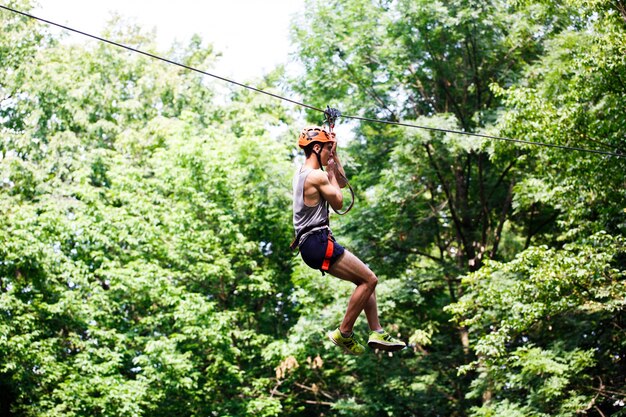 Man goes down on the rope in an entertainment park