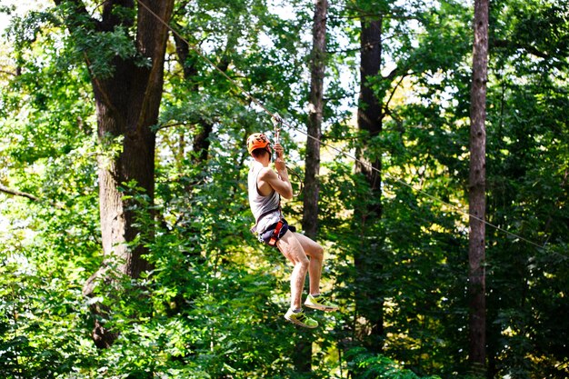 Man goes down on the rope in an entertainment park