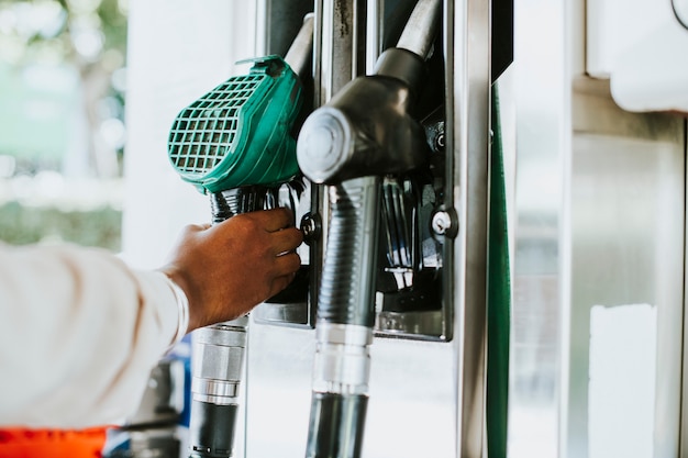 Man grabbing a fuel nozzle to refuel his vehicle