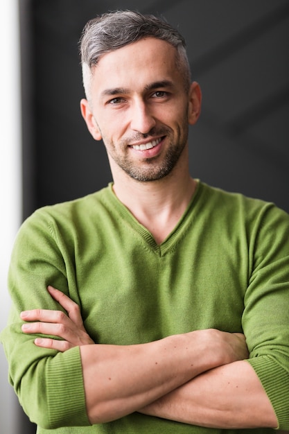 Free photo man in green shirt having his arms crossed