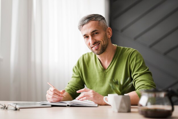 Man in green shirt sitting at his desk