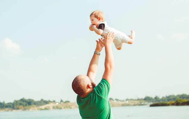 Man in green shirt throws his child up