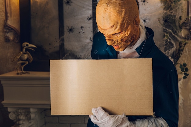 Man in Halloween mask standing with tablet