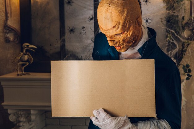 Man in Halloween mask standing with tablet