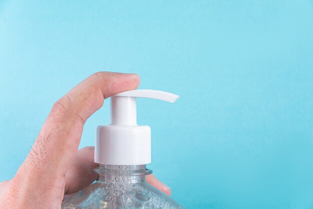 Man hand in container with alcohol gel 