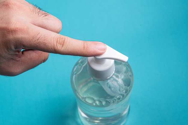 Man hand in container with alcohol gel 