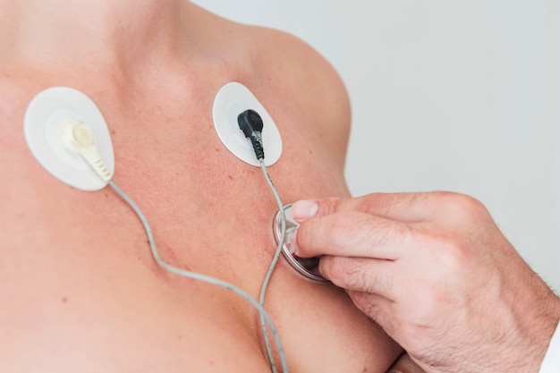 Man hand with stethoscope checking respiration of woman