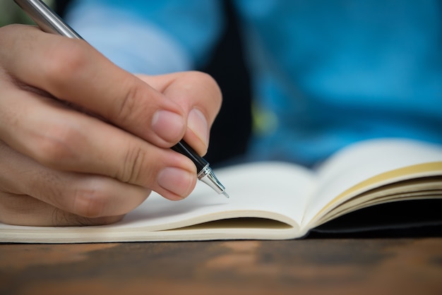 Man hand write on the notebook.