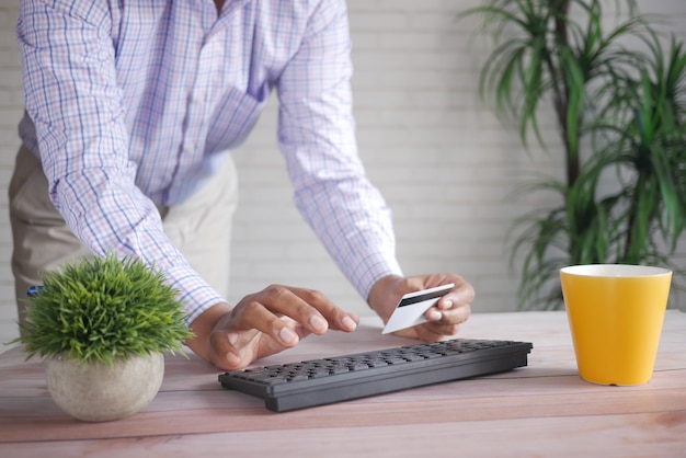 Человек руки, держа кредитную карту и используя ноутбук, делая покупки в интернете