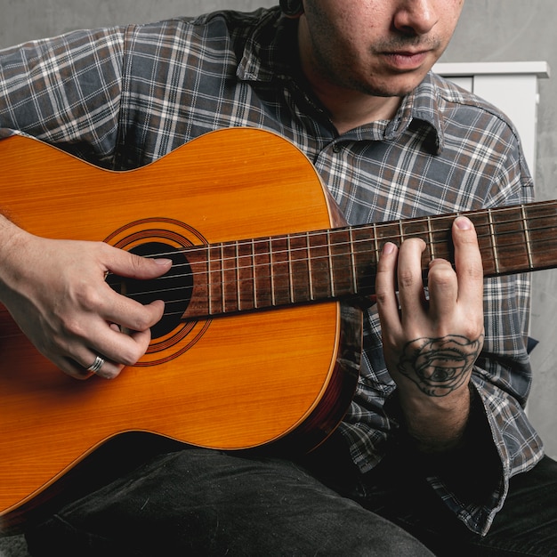 Man hands playing acoustic guitar