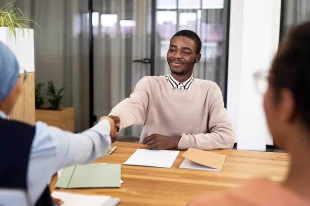 Man handshaking his employer after being accepted for his new office job