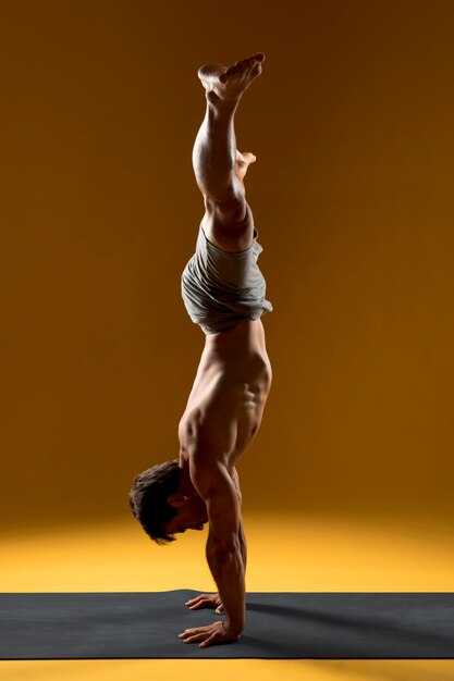 Man in handstand pose on yoga mat