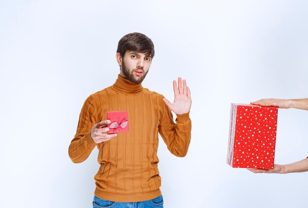 남자는 빨간색 선물 상자를 가지고 있고 다른 선물을 거부합니다.
