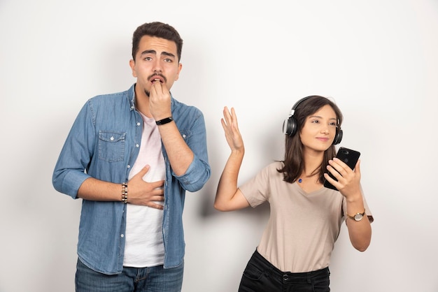 Man having breakdown while woman dancing around music.