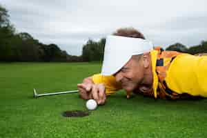 Foto gratuita uomo che ha una partita di golf all'aperto sul campo