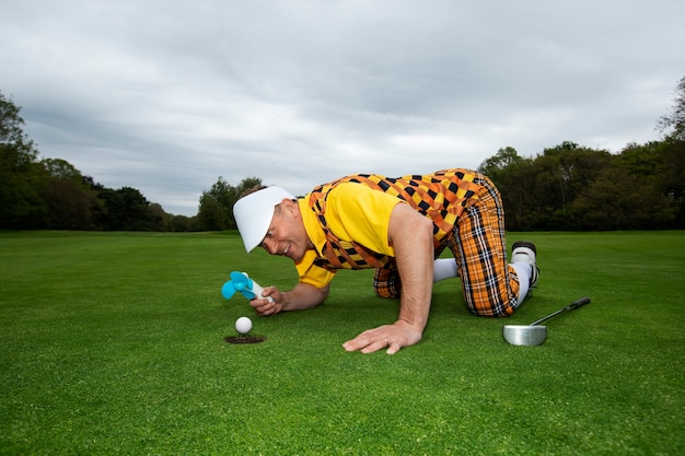 Foto gratuita uomo che ha una partita di golf all'aperto sul campo