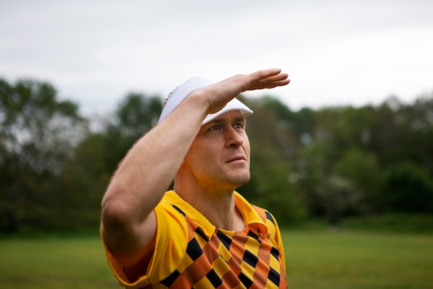 Free photo man having a game of golf outdoors on the field