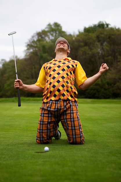 Мужчина играет в гольф на открытом воздухе