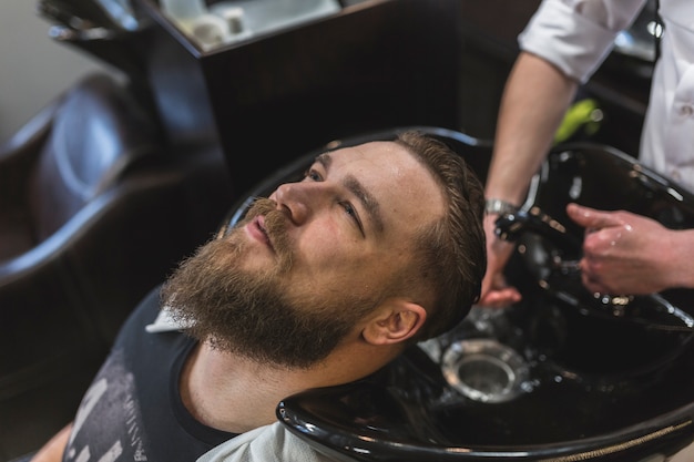 Man having hair washed by barber