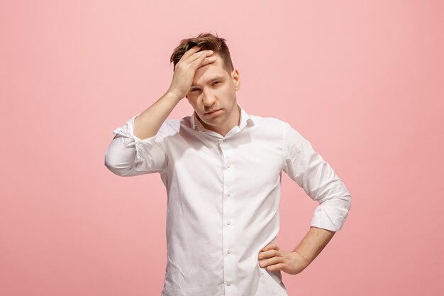 Man having headache. Isolated over pink wall.