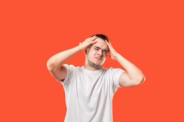 Man having headache. Isolated over red .