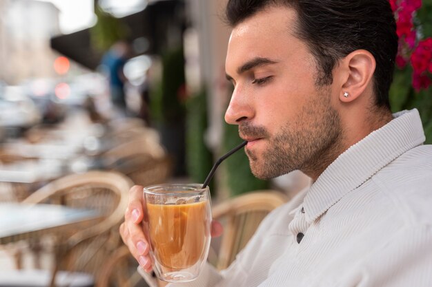 屋外でアイスコーヒーの休憩をとっている男