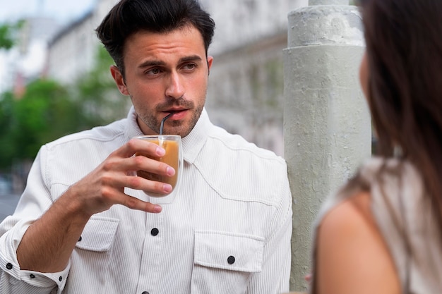 Man having an iced coffee break outdoors