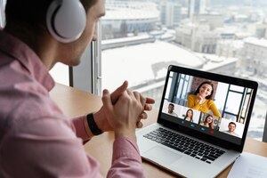 Free photo man having an online video call with coworkers