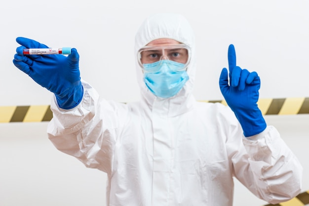 Free photo man in hazmat suit with blood sample