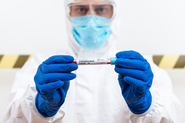 Free photo man in hazmat suit with blood sample