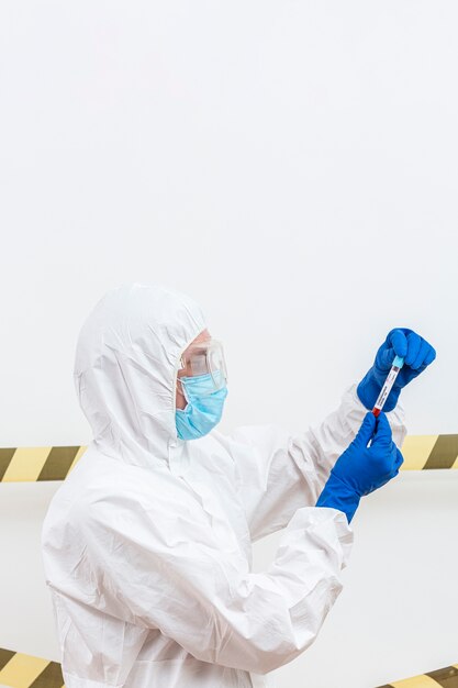 man in hazmat suit with blood sample