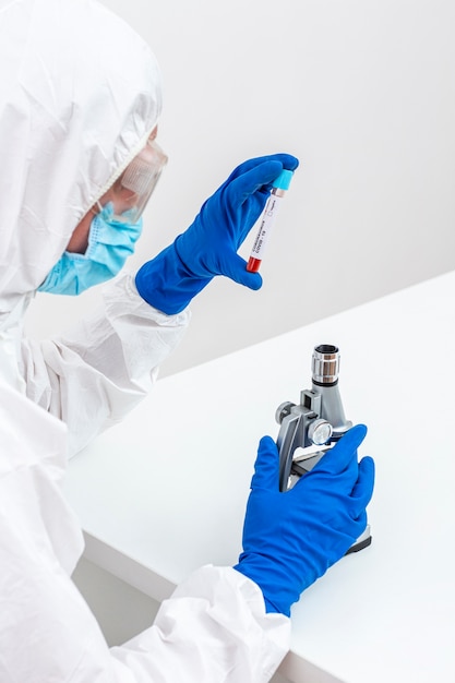 Man in hazmat suit with blood sample