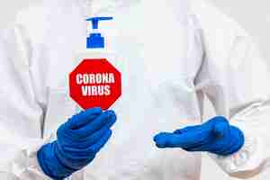 Free photo man in hazmat suit with coronavirus stop sign