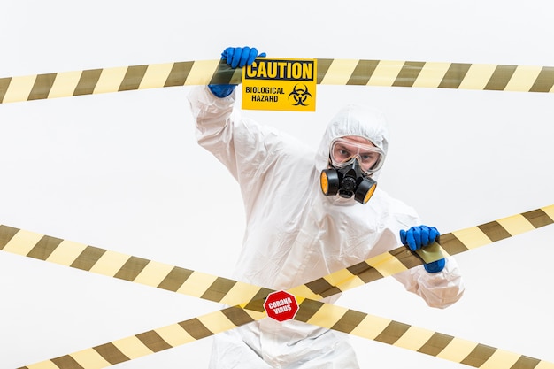 Foto gratuita uomo vestito di hazmat con segno di pericolo