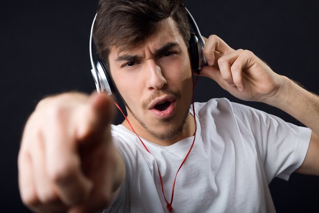 "Man in headphones pointing at camera"