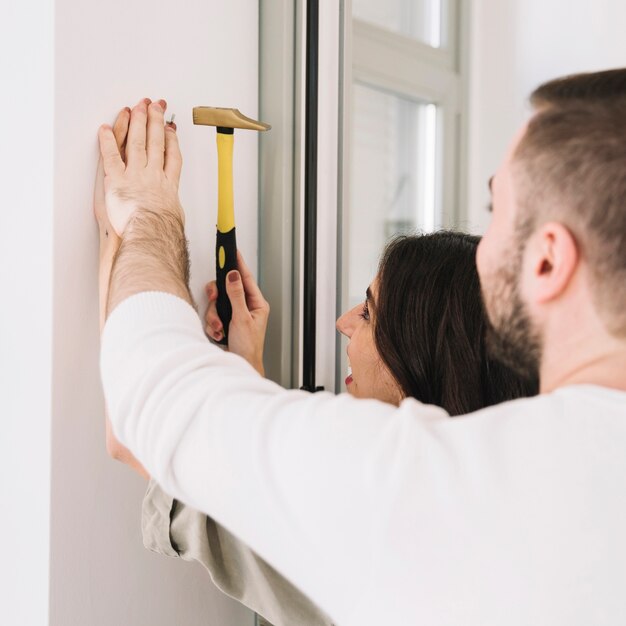 Man helping with nail to woman