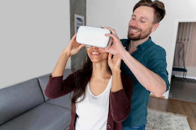 Man helping woman put on virtual reality headset