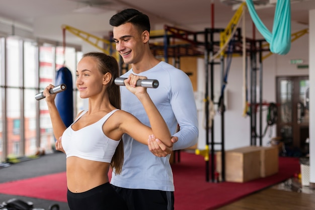 Man helping woman with her exercise