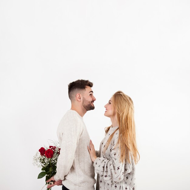 Free photo man hiding roses from woman