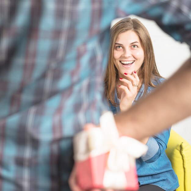 Man hiding surprise gift from his happy girlfriend