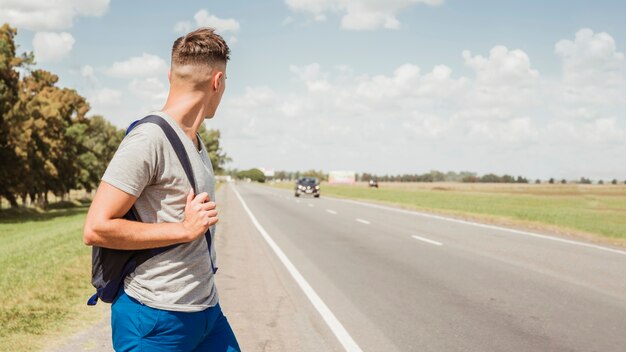 Man hitchhiking on a road