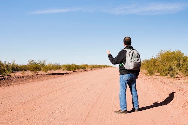 Man hitchhiking on the road