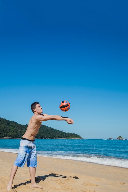 Free photo man hitting volleyball