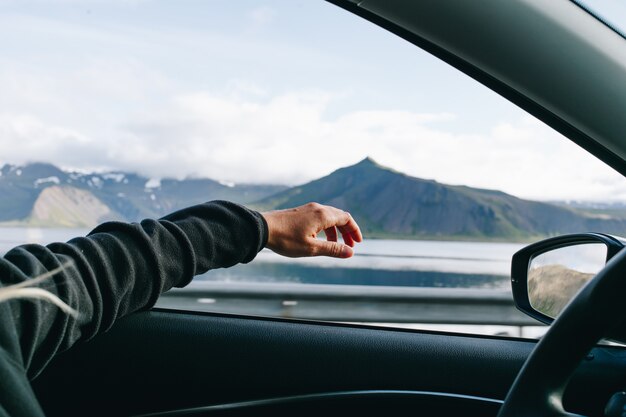 車を運転するときに男が手を差し伸べる