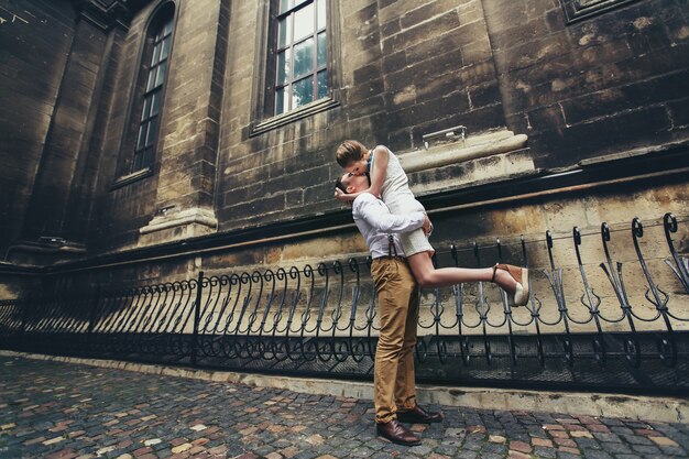 Man hold shis lady up kissing her before the church