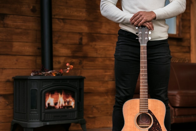 Foto gratuita uomo che tiene la chitarra acustica