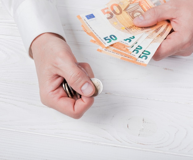 Man holding bank-notes and coins