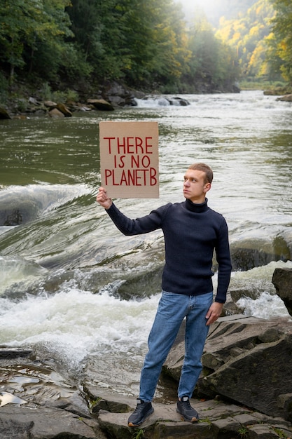 man holding banner with message full shot