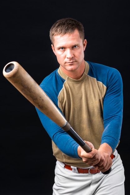 Free photo man holding baseball bat and posing